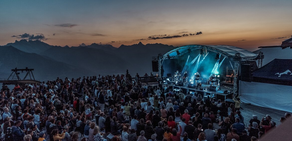 Konzert am Kapell - Silvretta Montafon | © Silvretta Montafon Ein Konzert beim Sonnenuntergang mit bunter Beleuchtung und großem Publikum | © Silvretta Montafon